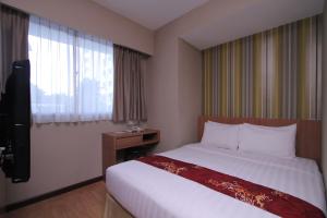 Habitación de hotel con cama y ventana en Likas Square - KK Apartment Suite en Kota Kinabalu