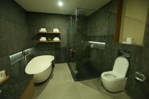 a bathroom with a toilet and a glass shower at Escala Tagaytay in Tagaytay