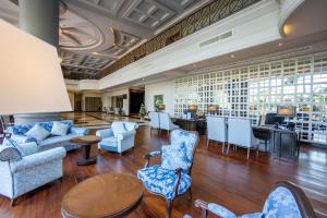 a lobby with blue chairs and tables and a bar at The Grand Riverside Hotel in Phitsanulok