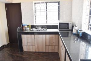 a kitchen with a sink and a microwave at VENUS HOMES in Mangalore