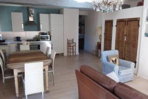 ein Wohnzimmer und eine Küche mit einem Tisch und einem Sofa in der Unterkunft L'Appart à Cotignac, tout compris, calme et confort in Cotignac