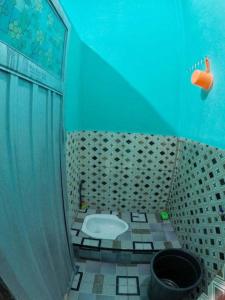 - Baño con aseo en habitación azul en Penginapan asidik, en Bira