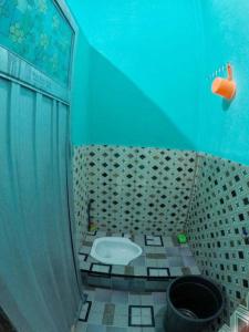 a bathroom with a toilet in a blue room at Penginapan asidik in Bira