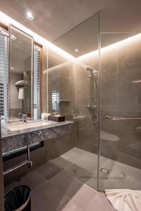 y baño con ducha y lavamanos. en The Grand Riverside Hotel en Phitsanulok