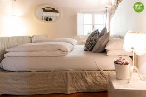 ファガーニャにあるStop & Sleep Fagagna on the Hillsのランプと枕が備わるドミトリールームのベッド1台分です。