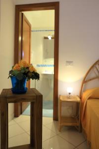 ヴァルデーリチェにあるResidence Tamareaの花瓶付きのテーブルが備わるベッドルーム1室