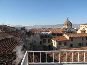 una vista de una ciudad con humo saliendo de los edificios en Hotel Patria, en Pistoia