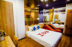een kamer met twee bedden en een tafel erin bij Mata Love Hotel in Da Nang