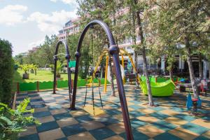 a playground in a park with a green playground at Flamingo Hotel Sunny Beach in Sunny Beach