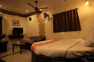 a bedroom with a bed and a living room at Hotel Pratap Heritage in Mahabaleshwar