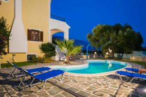 a villa with a swimming pool and two lounge chairs at Villa Cara in Kourkoumelata