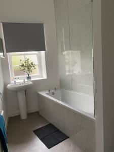 a bathroom with a bath tub and a sink at Union Street Apartment in Hawick