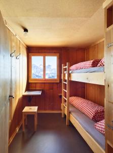 Zimmer mit 2 Etagenbetten und einem Fenster in der Unterkunft Schifer Berghaus in Klosters