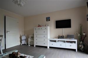 ein Wohnzimmer mit einer weißen Kommode und einem TV in der Unterkunft Darsskrabbe in Prerow
