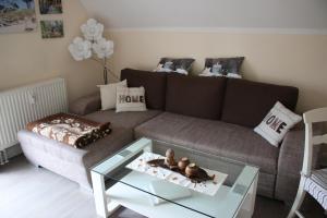 ein Wohnzimmer mit einem braunen Sofa und einem Glastisch in der Unterkunft Darsskrabbe in Prerow