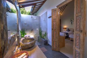 een badkamer met een wastafel, een douche en een bed bij Wide Sands Beach Retreat in Pulukan