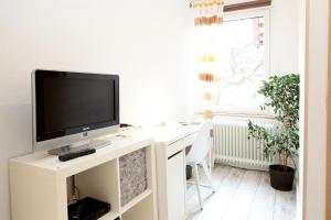 ein weißer Schreibtisch mit einem TV darüber in der Unterkunft Hotel Goldener Löwe in Einbeck