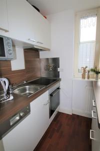 Una cocina con gabinetes blancos y un fregadero y una ventana. en Darsskrabbe, en Prerow 24 fotos más