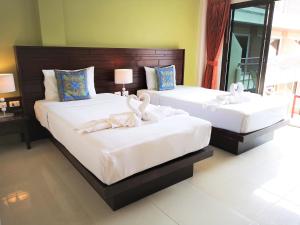 twee bedden in een hotelkamer met zwanen erop bij Seven Seas Hotel in Patong Beach