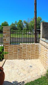 una pared de ladrillo con una valla en un parque en Starfish Villa, en Nea Iraklitsa