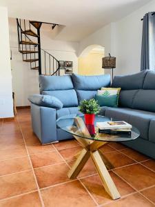 ein blaues Sofa im Wohnzimmer mit einem Tisch in der Unterkunft LA CRUZ DE LA ATALAYA in Benamahoma