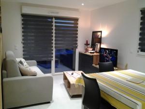 ein Schlafzimmer mit einem Bett und einer Couch und einem Fenster in der Unterkunft Les balcons la haie des grisselles in Gérardmer