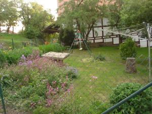 a garden with a fence and a swing at Anitas Landerlebnis in Witzenhausen