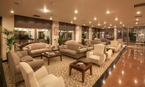 a waiting room with couches and chairs and tables at Grand Hotel Gaziantep in Gaziantep