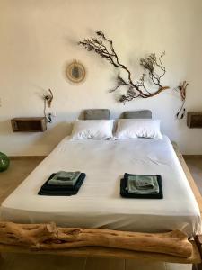 1 dormitorio con 1 cama con un árbol en la pared en I Ginepri, en Teulada