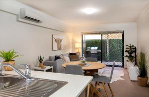 a kitchen and living room with a table and a couch at Stylish 3 bed, 300m to the beach Wifi, Parking, Glenelg South in Glenelg