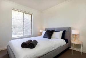 1 dormitorio con 1 cama con 2 toallas en Stylish 3 bed, 300m to the beach Wifi, Parking, Glenelg South en Glenelg