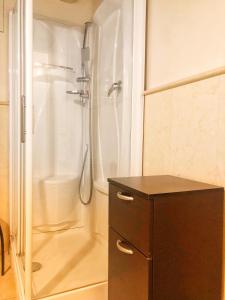 ベルガモにあるTerrazza Tassis Charme&Relaxのバスルーム(シャワー付)、木製キャビネットが備わります。