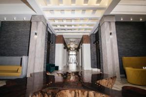 a lobby with a fountain in the middle of a building at Shato Hotel in Omsk