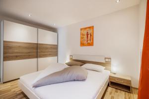 een slaapkamer met een groot wit bed in een kamer bij Apartment Viktoria in Castelbello