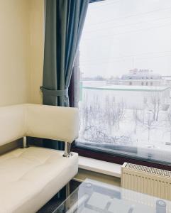 Zimmer mit Sofa und Fenster in der Unterkunft Yugorskaya in Surgut