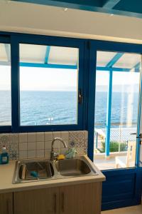 kuchnia ze zlewem i 2 okna z widokiem na ocean w obiekcie Iris Villas w mieście Spárton