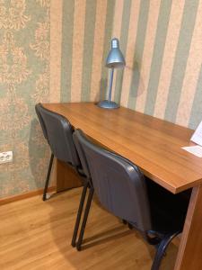 a desk with two chairs and a lamp on it at Hotel Khozyayushka in Perm