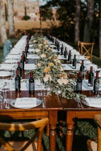 キウズディーノにあるアグリツーリズモ サン ガルガーノの長テーブル(ワインボトル、花付)