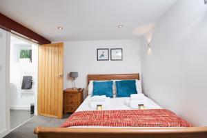 a bedroom with a large bed with blue pillows at The Little Apartment in Kegworth