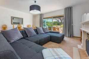 uma sala de estar com um sofá azul e uma mesa em Villa Moises em Albufeira