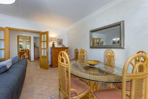 sala de estar con mesa, sillas y sofá en Villa Moises, en Albufeira