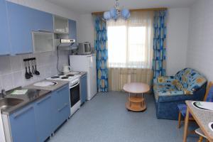 a kitchen with blue cabinets and a table and a chair at Гостиница "Дом aртистoв цирка" in Yekaterinburg