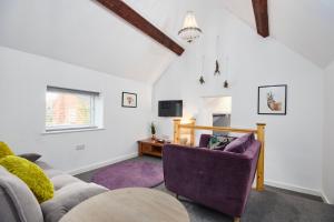 een woonkamer met een bank en 2 stoelen bij The Wood Loft in Kegworth