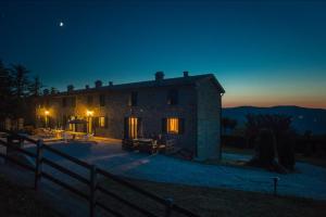 Una casa di pietra di notte con la luna nel cielo di Agriturismo Prato Grande a Loiano