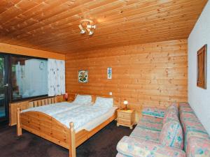 ein Schlafzimmer mit einem Bett und einem Sofa in der Unterkunft Ferienwohnung mit Sauna in Gargellen - A 064.006 - 8 in Gargellen