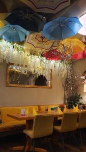 
a dining room table with umbrellas hanging from the ceiling at Pension Da Gigi in Oschersleben
