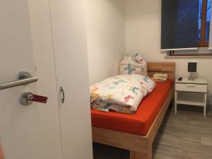 1 dormitorio pequeño con 1 cama con colchón rojo en Pension Jägerschenke, 