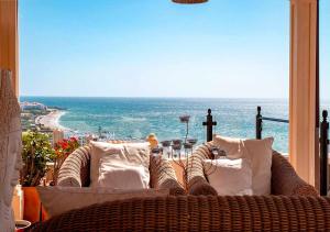 wiklinowy fotel siedzący na balkonie z widokiem na ocean w obiekcie Spectacular views of the sea, Punta Lara, Nerja, Nº7 w mieście Nerja