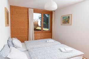 Schlafzimmer mit einem Bett und einem Fenster in der Unterkunft Chalet Lyngen in Leysin