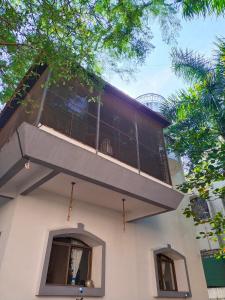 a building with a balcony on top of it at Hostel Lifespace- Garden Bungalow with Pods, CoWork & Cafe in Pune